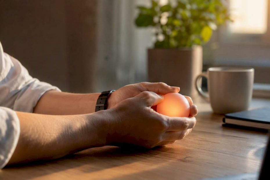 Jemand knetet am Schreibtisch einen Stressball in den Händen.