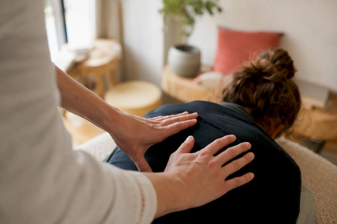 Hände des Coaches bei einer somatischen Entspannungstherapie