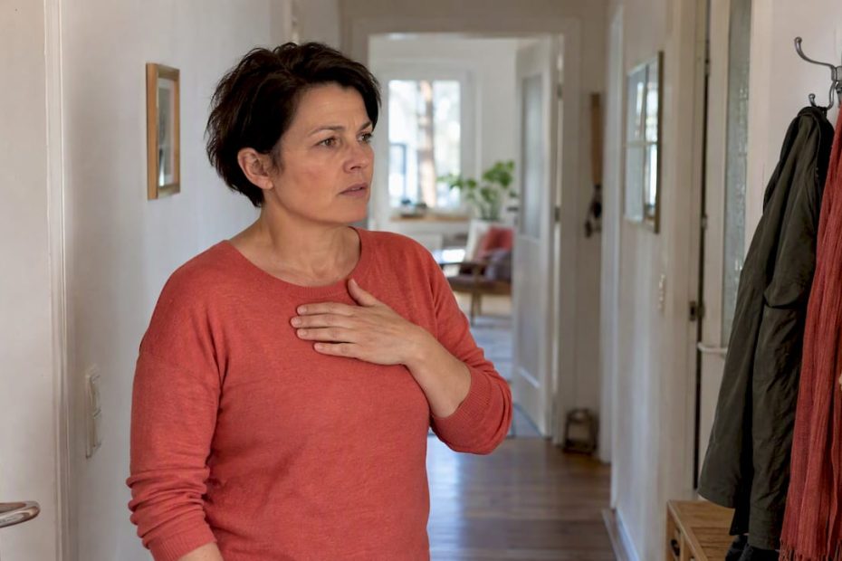 Eine Frau spürt ein Engegefühl in der Brust.