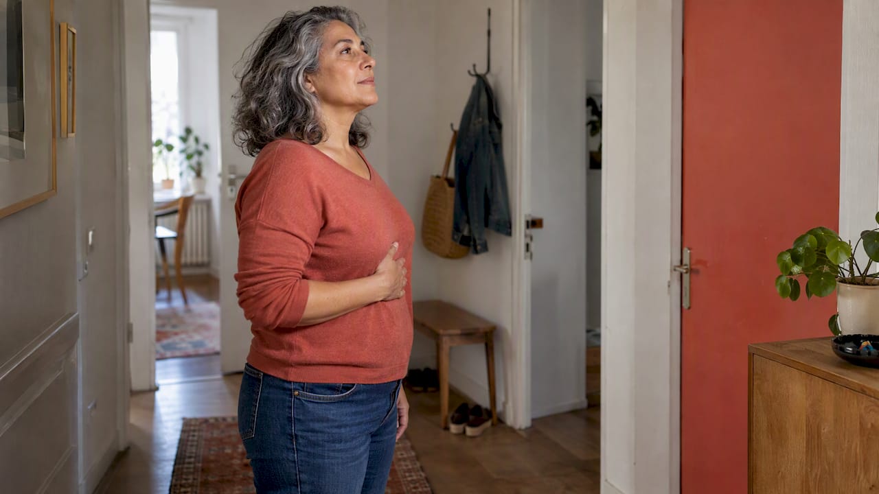 Die Frau nimmt bewusst ihren Atem und ihre Körperhaltung wahr.